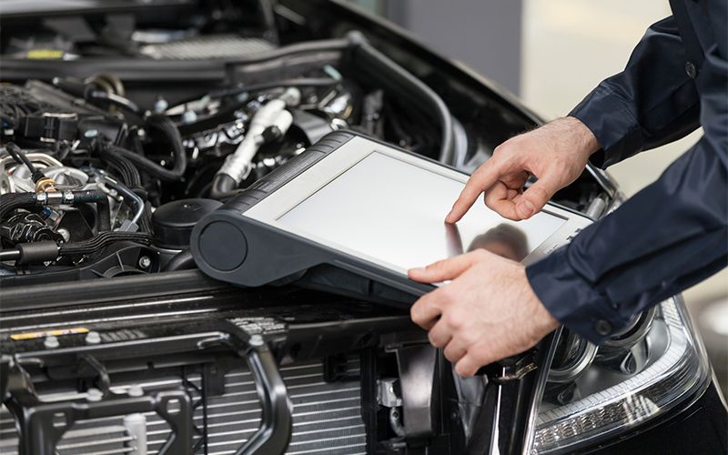 Technician using a diagnostic tablet on an engine